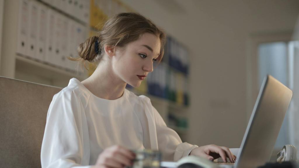 Persoon zit aan tafel met gedachten vol twijfel. Beeld van de innerlijke criticus en het impostor fenomeen dat groei en zelfvertrouwen belemmert.